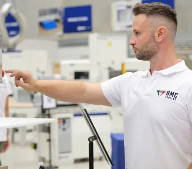 BMC Tooling specialist inspecting machined panels on the factory floor
